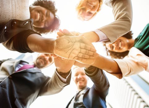 Low Angle Photo of People Doing Huddle Up
