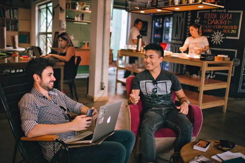 Photograph of Men Having Conversation Seating on Chair
