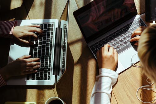 Crop women typing on laptop keyboard