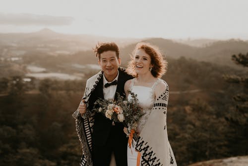Photo of Couple Smiling While Standing Next to Each Other